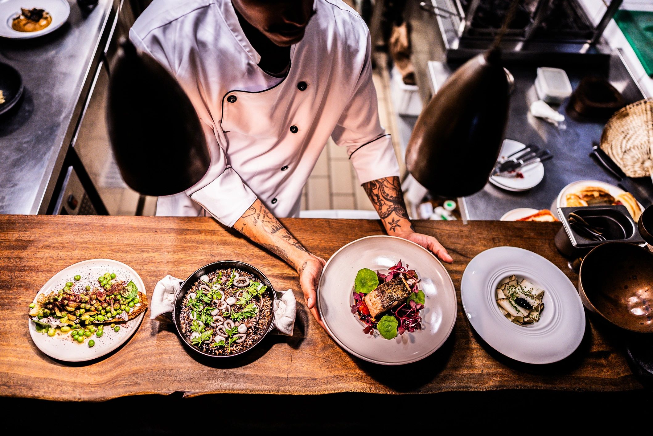 Chef preparing a plated dish in a restaurant kitchen